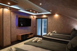 1 Schlafzimmer mit 2 Betten und einem Flachbild-TV in der Unterkunft Motel Lašva in Zenica