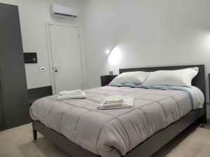 ein Schlafzimmer mit einem Bett mit zwei Handtüchern darauf in der Unterkunft Gemini rooms in Crotone