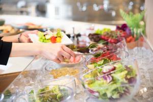 une table recouverte de assiettes de nourriture et de bols de salade dans l'établissement Richmond Hotel Utsunomiya-ekimae Annex, à Utsunomiya
