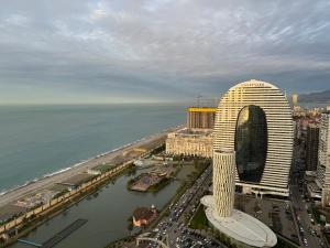 uma vista aérea de um edifício ao lado de uma massa de água em Sea View Panoramic Suite Orbi City em Batumi