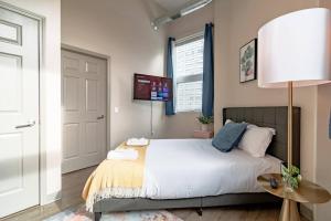 1 dormitorio con cama, lámpara y puerta en McCormick 2br/2ba Oasis with optional Parking, Patio, Gym for up to 6 guests, en Chicago