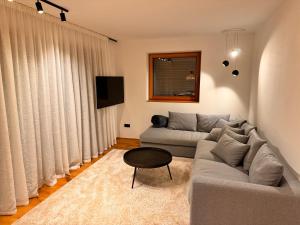 a living room with a couch and a table at Dreamy Apartment by Lake Haider and Lake Reschen Uniting Luxury, Nature and Relaxation in San Valentino alla Muta