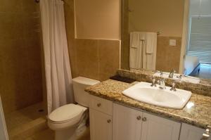 a bathroom with a sink and a toilet and a mirror at Ocean Villa Supreme in Bailey Town