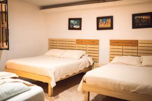 a bedroom with two beds and two pictures on the wall at Hotel Raíces Casona Real in Santa Rosa de Cabal