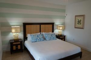 a bedroom with a bed with blue pillows and two lamps at Ocean Villa Supreme in Bailey Town