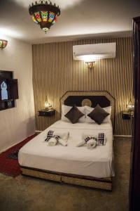 Un dormitorio con una cama con dos personas. en Riad Merzouga en Fez