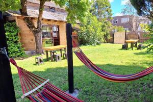 a hammock in a yard with a log cabin at MaPatagonia Hostel Monumento Nacional in Puerto Varas
