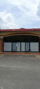 a garage with white doors and a red roof at Ninizam Kemaman Cukai Homestay in Cukai