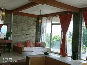 a living room with a couch and large windows at Rara Villas Lombok in Senggigi 