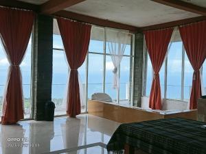 a bedroom with large windows with red curtains at Rara Villas Lombok in Senggigi 