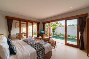 - une chambre avec un lit et une vue sur la piscine dans l'établissement Narada Suite & Villa, à Ubud