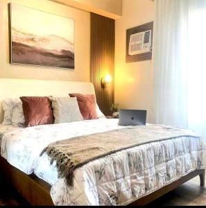 a bedroom with a bed with a laptop on it at Tehillah Residences in Bacolod