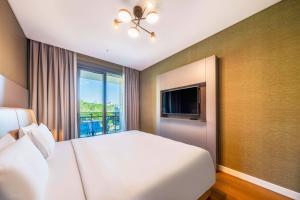 a bedroom with a white bed and a large window at Radisson Residences Vadistanbul in Istanbul