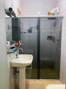 a bathroom with a sink and a glass shower at Casa na Orla de Lagoa Santa in Lagoa Santa