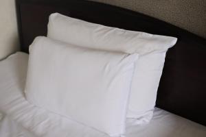a white pillow sitting on top of a bed at Hotel Honjo in Honjo