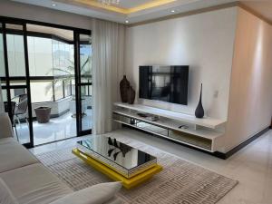 a living room with a tv and a couch at Apt de luxo na Praia do Morro c/ vista para o mar in Guarapari