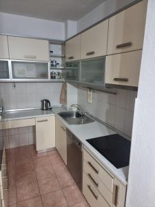 - une cuisine avec des placards blancs et un évier dans l'établissement Cozy Apartment, à Strumica