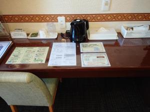uma mesa de madeira com panfletos e uma máquina de café em Hotel Honjo em Honjo