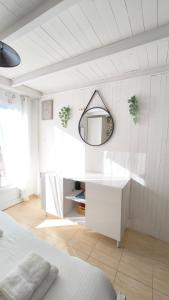 a white bedroom with a mirror and a bed at L'Excursion - Charmant T2 Rénové proche de la mer in Cassis