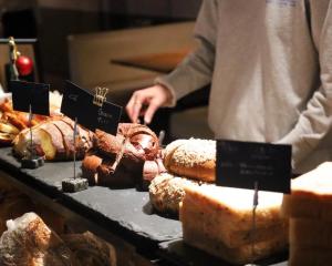 a person standing in front of a buffet of food at THE KNOT TOKYO Shinjuku in Tokyo