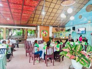 a group of people sitting at a table in a restaurant at Coco Grove Nature Resort in Himensulan