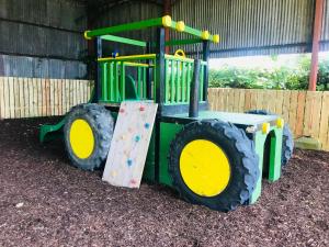 un tractor verde y amarillo en un parque infantil en Cavan House, en Rathfriland