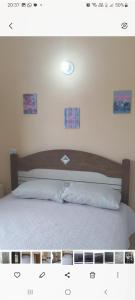 łóżko z drewnianym zagłówkiem w sypialni w obiekcie Linda casa em Condomínio no Sahy w mieście Mangaratiba