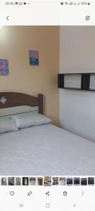 1 dormitorio con 1 cama con colcha blanca en Linda casa em Condomínio no Sahy en Mangaratiba