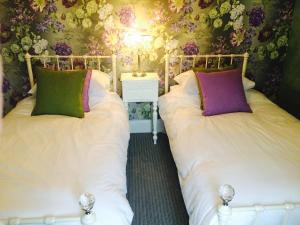 dos camas sentadas una al lado de la otra en un dormitorio en Cavan House, en Rathfriland