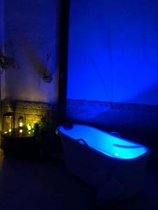 eine blaue Badewanne in einem dunklen Zimmer in der Unterkunft Suíte Verão na Praia in Cabo Frio