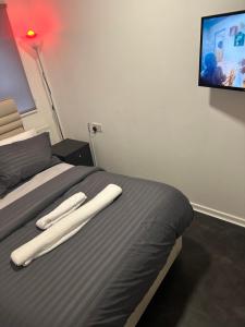 ein Schlafzimmer mit einem Bett mit zwei weißen Handtüchern darauf in der Unterkunft Manny’s in Madeley