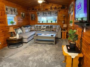 sala de estar con sofá y TV en The Lazy Bear Cabin en Long Lake