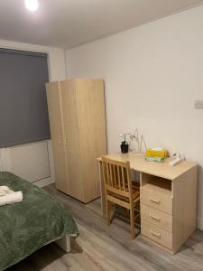 Cette chambre dispose d'un bureau, d'un lit, d'un bureau et de placards. dans l'établissement Lovely Triple and Quadruple Bedrooms in Euston, à Londres