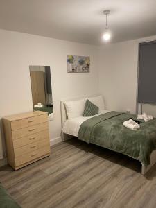 a bedroom with a bed and a dresser in it at Lovely Triple and Quadruple Rooms in Euston & Square in Central London in London