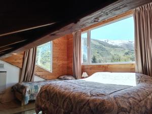 um quarto com uma cama e uma grande janela em Catedral View minimo 4 noches em San Carlos de Bariloche