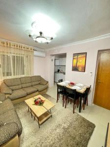 uma sala de estar com um sofá e uma mesa em Shkodra Apartment em Shkodër