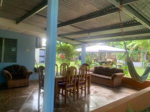 ein Wohnzimmer mit einem Tisch, Stühlen und einem Sofa in der Unterkunft Julianna Country House in Las Tablas