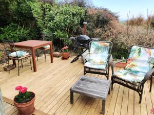 Haumoana的住宿－Haumoana Herb Cottage，庭院配有两把椅子、一张桌子和一张桌子