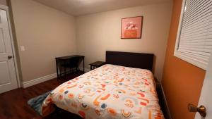 a bedroom with a bed with an orange and white comforter at Affordable Downtown Private Rooms in Windsor