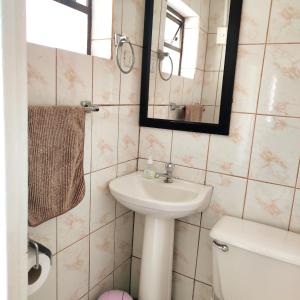 y baño con lavabo, espejo y aseo. en Cabaña Playera cómoda y central, en Viña del Mar