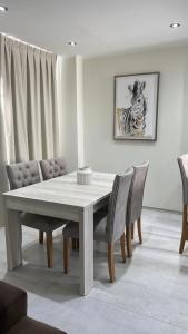 a dining room with a white table and chairs at Departamento General Paz in Villa María