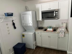 a small kitchen with a microwave and a refrigerator at Cozy private studio w/own yard - 3mi from Beach in Seminole