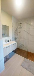 a white bathroom with a sink and a shower at Vibe Residence Dominicus in Bayahibe