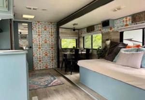 a bedroom with a bed and a dining room at Happy Camper - Close to Mackinac Island in Carp Lake