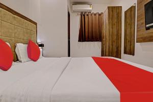 a bedroom with a large bed with red pillows at OYO Hotel Kishan in Mumbai