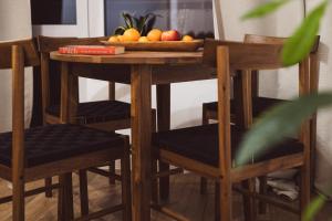 einen Tisch mit Stühlen und eine Obstschale darauf in der Unterkunft Apartament Fika - klimatyczny w centrum miasta by SpaceApart in Jelenia Góra