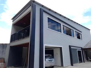 a white house with a car garage at Recanto dos Sonhos in Paraty