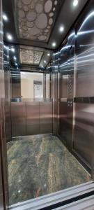 um elevador vazio num quarto com uma porta de vidro em Gran Hotel Palmeras em Jaén