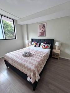 a bedroom with a bed with a stuffed animal on it at Entire 3 bed apartment in Ryde in Sydney