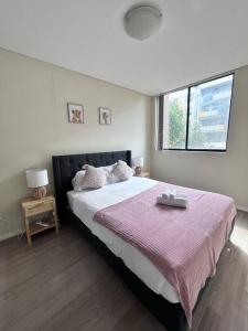 a bedroom with a large bed with a pink blanket at Entire 3 bed apartment in Ryde in Sydney